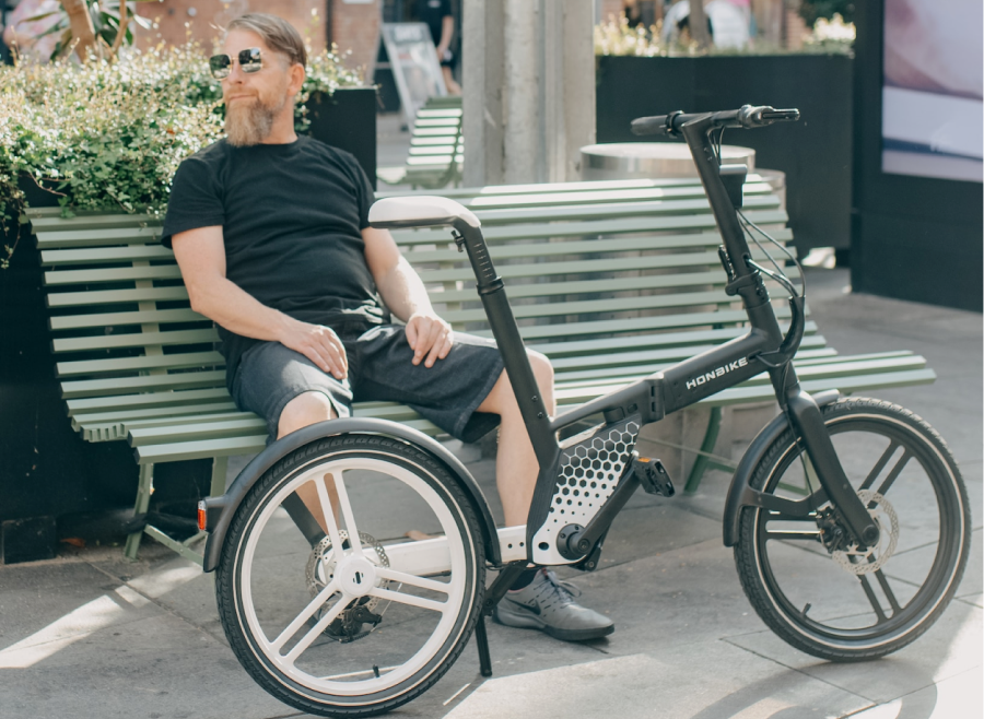Homme assis sur un banc à côté de son vélo
